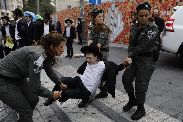 Israeli security forces carry away a young protester during a demonstration by Ultra-Orthodox Jews in Jerusalem on August 2, 2018. PHOTO: AFP