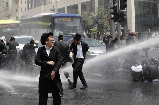  Ultra-Orthodox Jewish men are sprayed with water cannons by Israeli security forces during a protest in Jerusalem on August 2, 2018. PHOTO: AFP