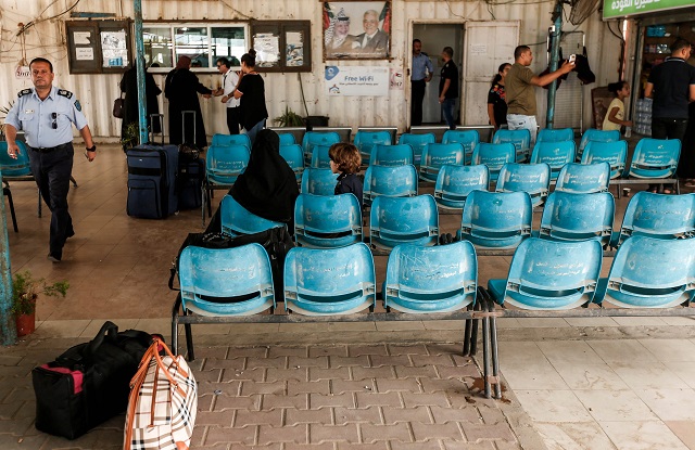 Palestinians wait while others present their travel documents to Palestinian Authority officers at the Erez crossing with Israel near Beit Hanun in the northern Gaza Strip on August 27, 2018. PHOTO: AFP