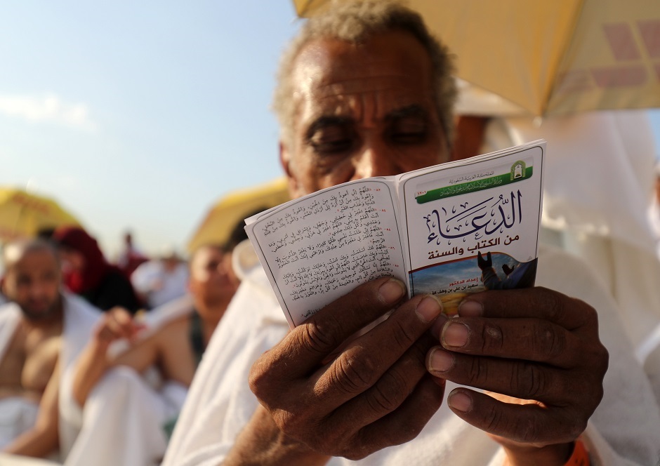 A pilgrim reads from a prayer leaflet atop Mount Arafat, during August 20, 2018. PHOTO:AFP