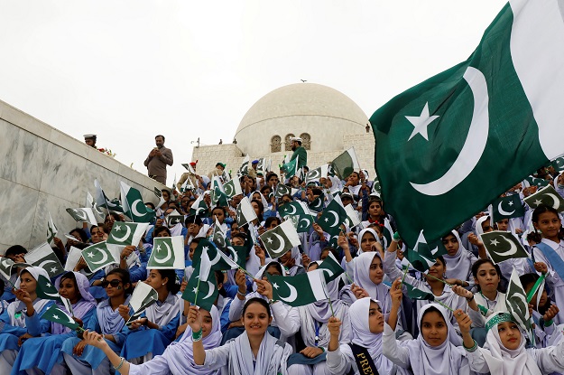  Attendees wave national flag while singing national songs at a ceremony to celebrate Independence Day in Karachi. PHOTO: REUTERS 