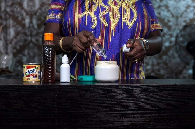 Elizabeth Kobiti mixes a skin lightening cream in her beauty salon in Lagos on July 13, 2018. PHOTO: AFP