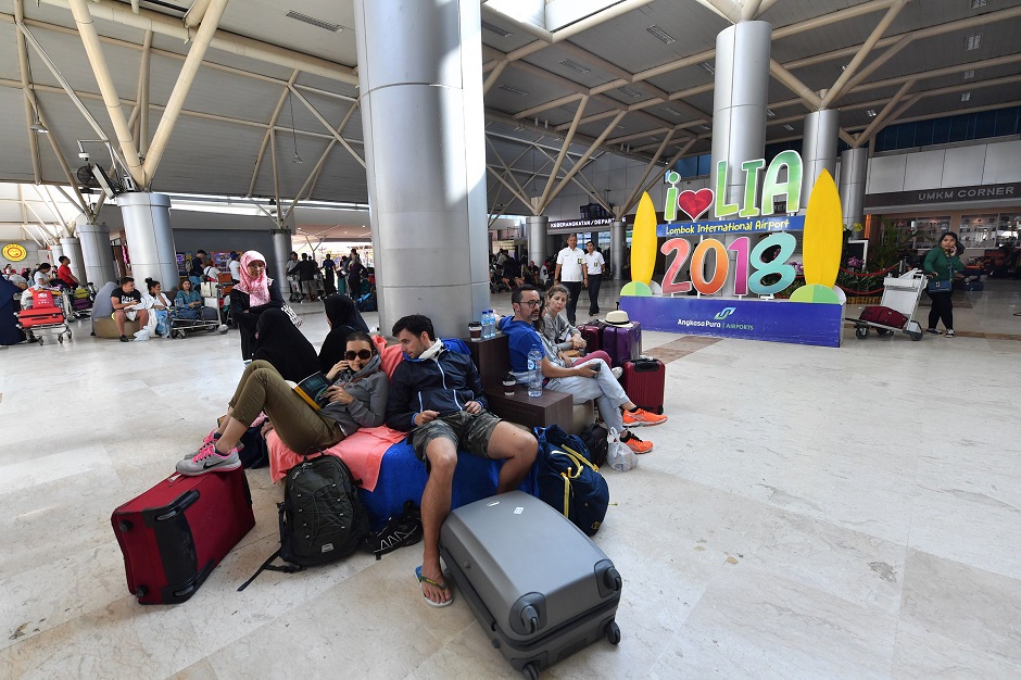 9.Tourists wait to depart from the Praya Lombok International Airport on the Indonesian island of Lombok PHOTO: AFP