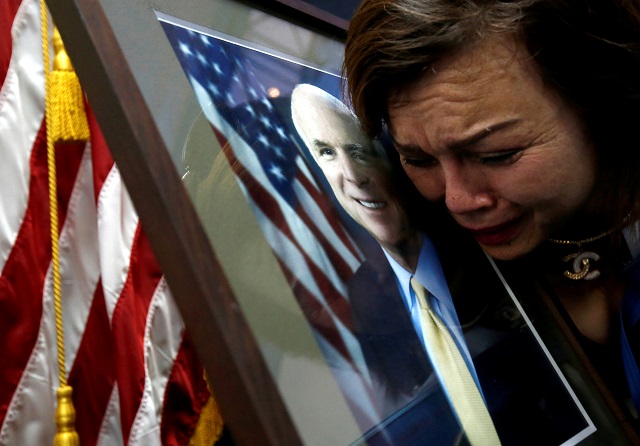 U.S. Vietnam-born citizen Mai Tran mourns near a portrait of U.S. Senator John McCain (R-AZ) after she paid respect to him at the U.S. embassy in Hanoi, Vietnam August 27, 2018. PHOTO: REUTERS
