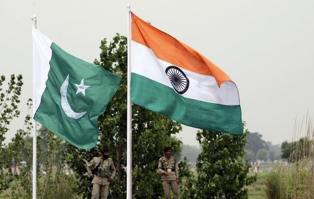 pakistani rangers stand near the indian and pakistani national flags during an annual fair near pakistan border in chamliyal photo reuters