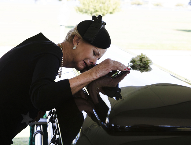 Cindy McCain lays her head on the casket of her husband Senator John McCain. PHOTO:AFP