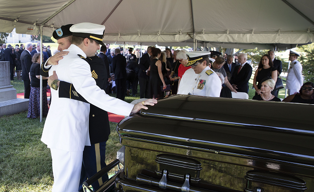 Jimmy McCain hugs his brother Jack McCain, touching casket, as Cindy McCain, watches during a burial service for Senator John McCain. PHOTO:AFP