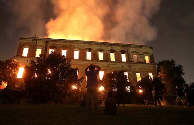 People watch as years of research turn to ashes. PHOTO: AFP