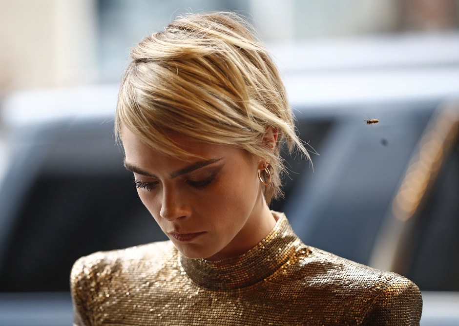 A bee flies near Cara Delevingne as she arrives at the world premiere of 