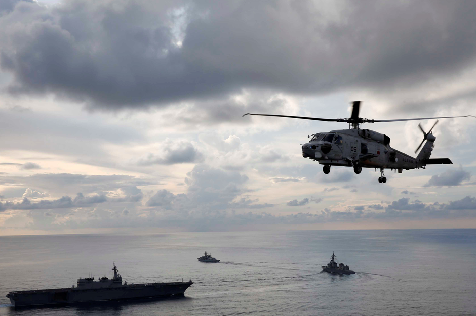  An SH-60K Sea Hawk helicopter flies in front of Japanese helicopter carrier Kaga (L) , Japanese destroyer Inazuma (C) and British frigate HMS Argyll taking part in a joint naval drill in the Indian Ocean. Reuters