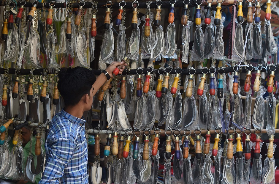 A man chooses knives mounted on chains during the first ten days of Muharram in Lahore on September 18, 2018. PHOTO:AFP