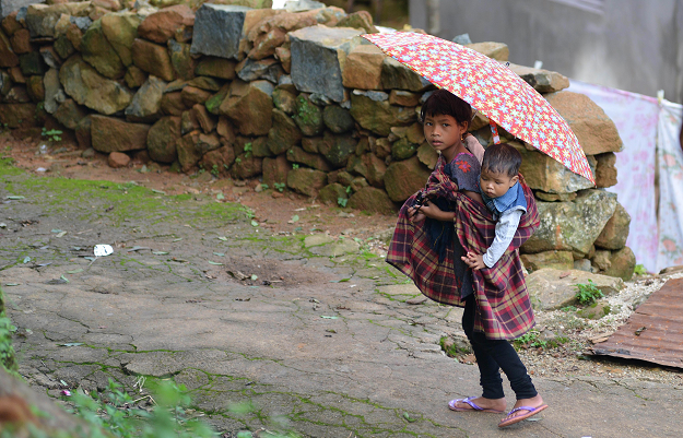 A child carrying a sibling in Kongthong village. PHOTO: AFP
