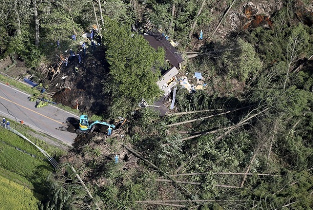 Police officers and rescue workers search for survivors from a building damaged by a landslide caused by a powerful earthquake in Atsuma town in Japan's northern Island of Hokkaido PHOTO: REUTERS