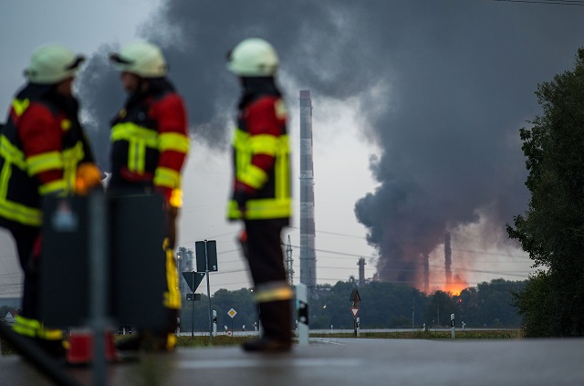 Firefighters stand next to the site of a refinery of Bayernoil company where an explosion took place on early September 01, 2018. PHOTO: AFP