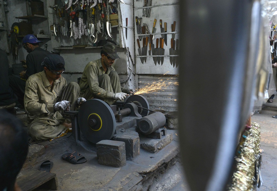 Pakistani vendors sharpen knives mounted on chains during the first ten days of Muharram in Lahore on September 18, 2018. PHOTO:AFP