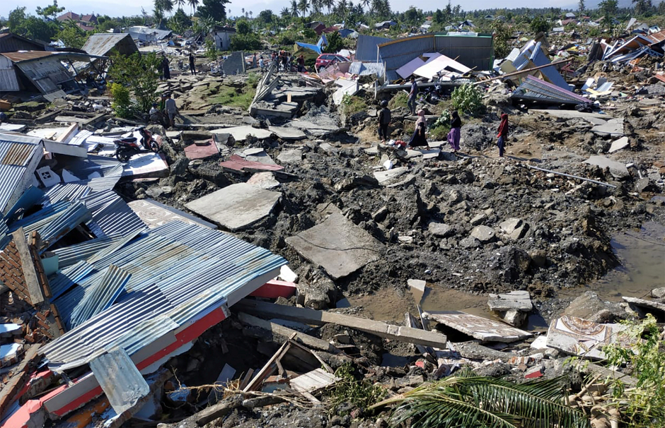 People walk through the ruins of a residential area in the wake of a powerful tsunami-quake in Palu. PHOTO: REUTERS