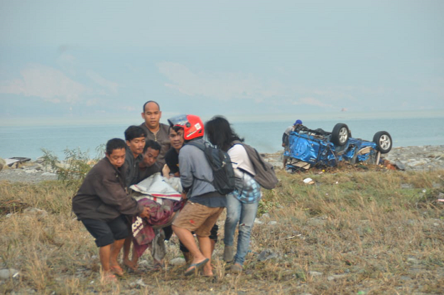 Residents carry a victim after after an earthquake and a tsunami AFP