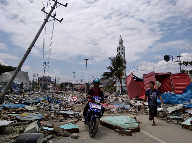 Residents make their way along a street full of debris after an earthquake and tsunami hit Palu, on Sulawesi island AFP