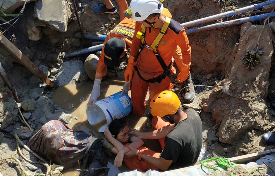 Search and rescue workers help rescue a person trapped in rubble. PHOTO: REUTERS