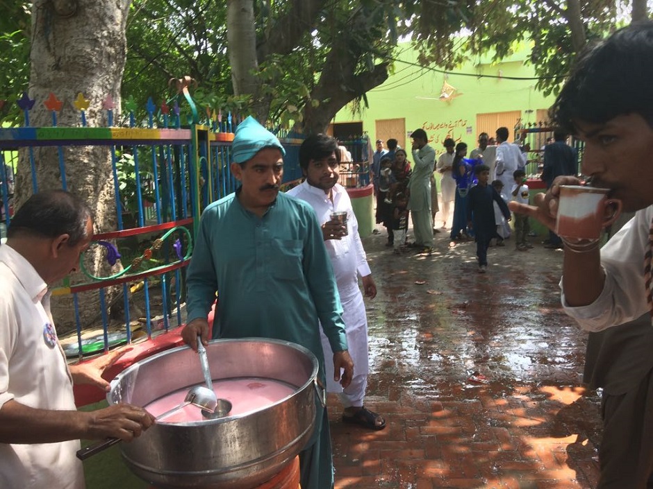 Devotees distributing flavoured milk. PHOTO: RIAZ AHMAD/EXPRESS