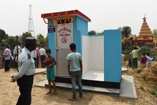 a private security guard and villagers gather around a newly built public toilet by boeing india photo afp