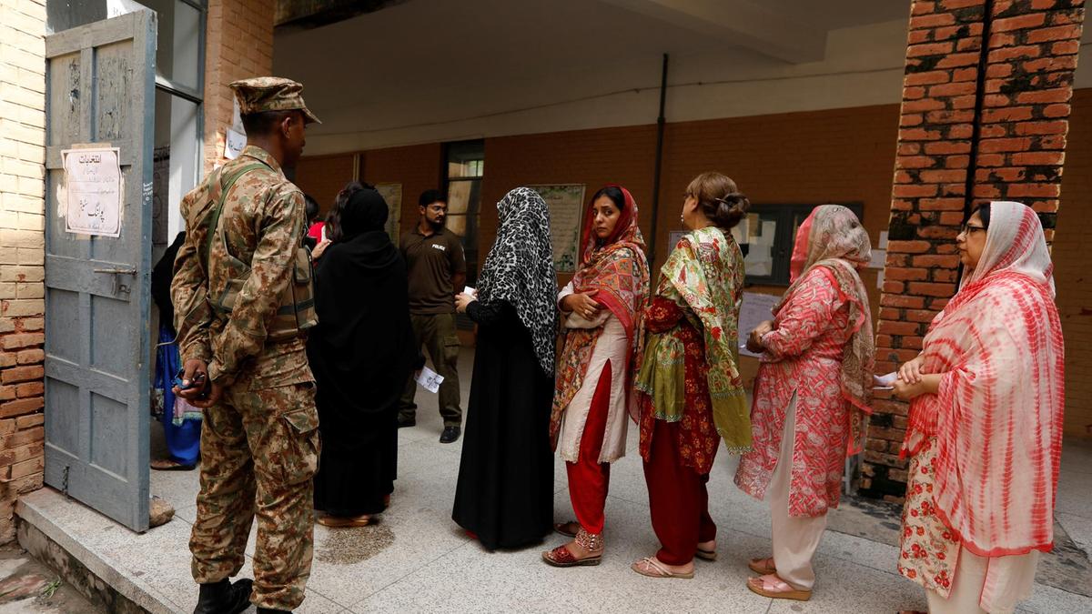 a soldier keeps watch as voters line up to enter at a polling station during general elections 2018 photo reuters