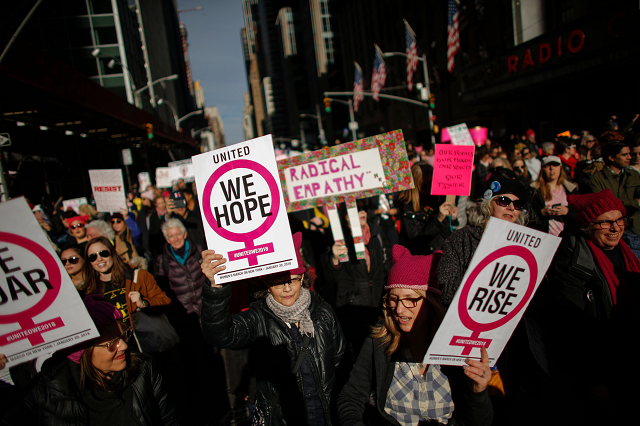 a photograph of people holding signs as they attended the womens march in new york city in january 2018 photo afp