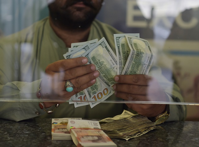 a currency dealer counts us dollars at a currency exchange shop in islamabad on october 9 photo afp