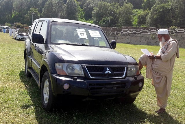 a man writes down the details of a government owned car on sale during an auction at the premises of pm house in islamabad sept 17 2018 photo reuters