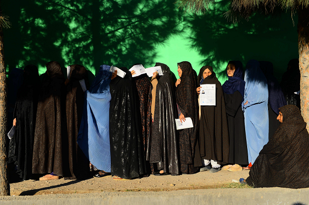 Afghan women wait in line to vote at a polling centre for the country's parliamentary election. PHOTO: AFP