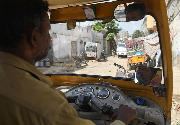 Pakistani auto-rickshaw driver Mohammad Rasheed drives his rickshaw in Korangi, a slum area in the eastern district of Karachi. PHOTO: AFP