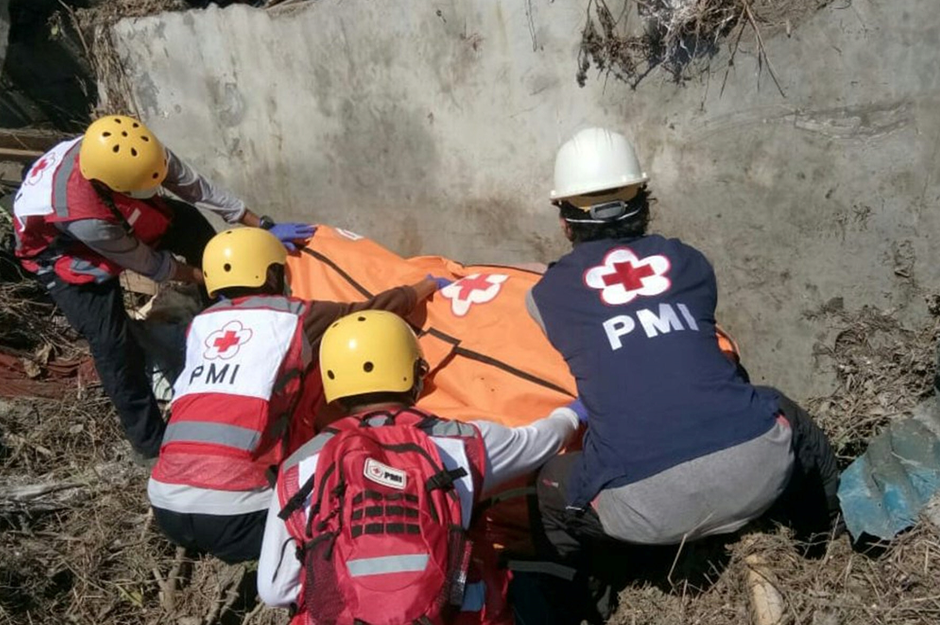 Indonesia Red Cross personnel recover a body in Palu, Indonesia. Reuters