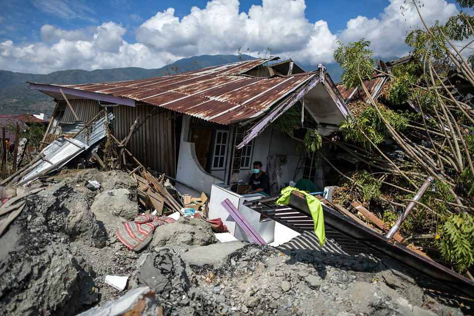 A man sits in a badly damaged house at Perumnas Balaroa village in Palu.  AFP