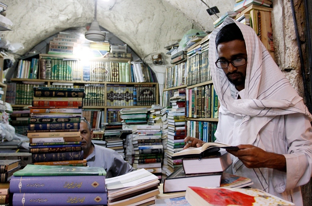A religious student pages a book at the Howeish book market in the holy city of Najaf, AFP