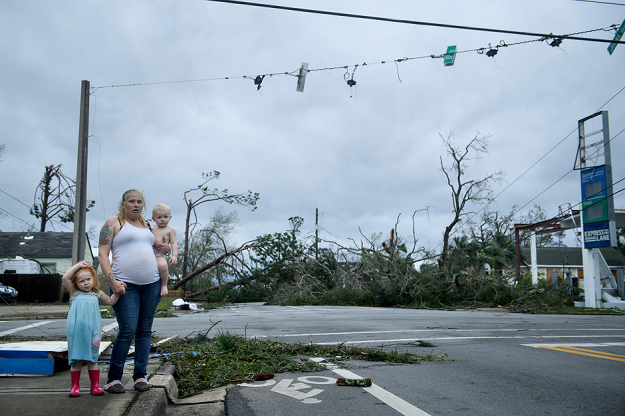 A woman and her children wait near a destroyed gas station in Panama City, Florida. PHOTO AFP