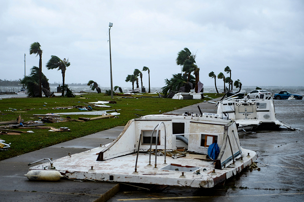Damaged boats and cars are seen in a marina. PHOTO AFP
