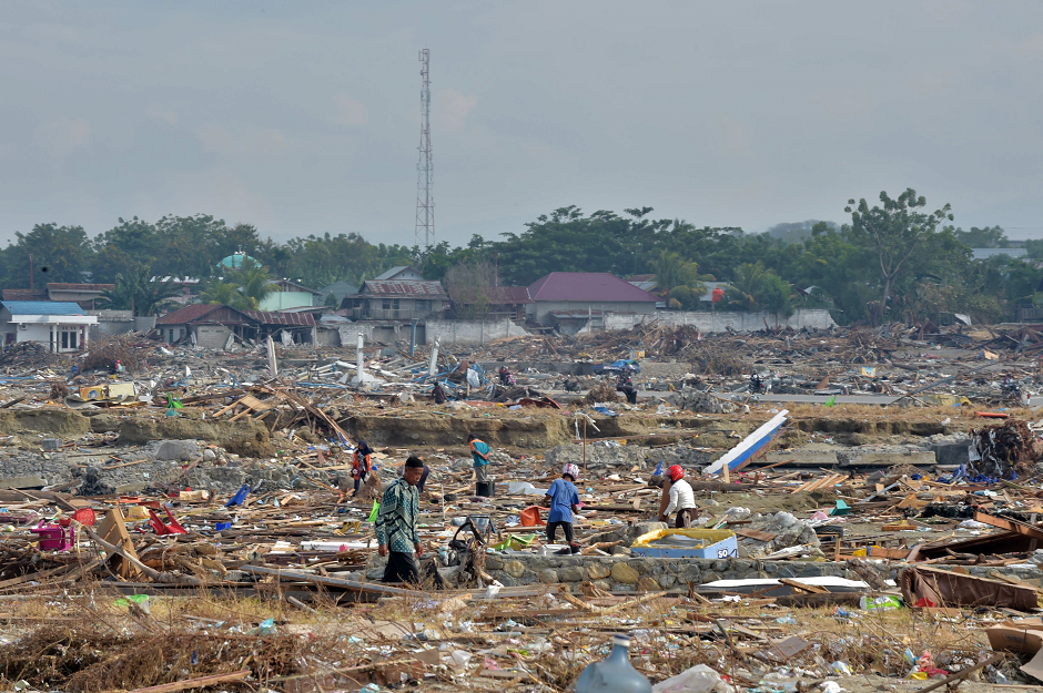 Indonesian people check for valuable items at a devastated area in Mamboro AFP