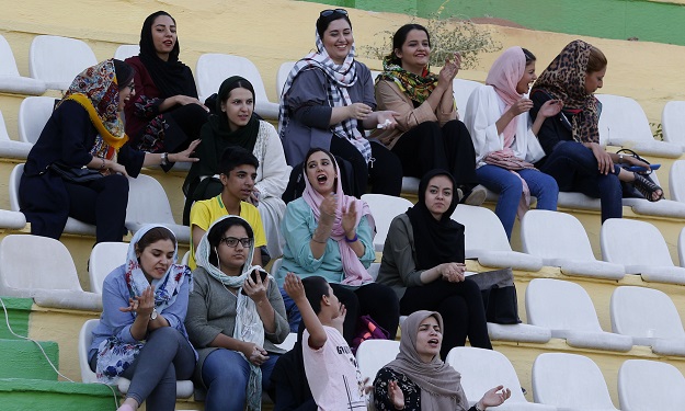 3.Iranian fans watch street children sponsored by the Imam Ali Foundation during a football tournament in Tehran on August 15, 2018. - The Imam Ali Foundation, recently held a football tournament for street kids, it was a reminder of Iran's diversity, as Azeris, Baluchis, Kurds and many others were thrown together on the pitch in the capital Tehran.  PHOTO: AFP