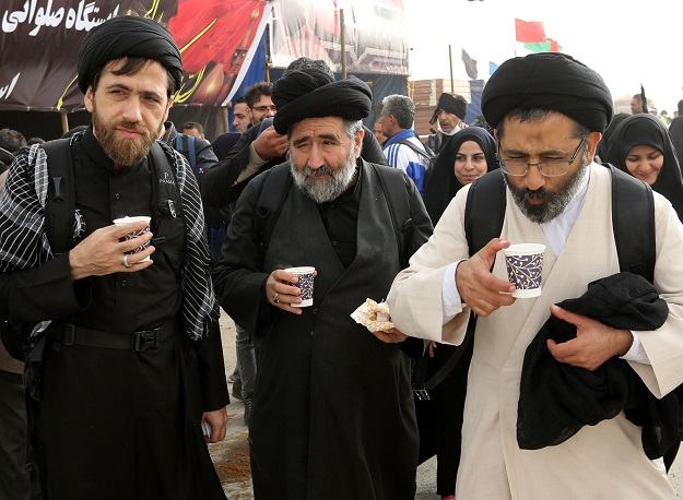 Iranian pilgrims have a hot drink as they prepare to cross the Mehran border point between Iran and Iraq, where thousands of Shiite Muslim believers were heading towards the central Iraqi shrine city of Karbala on October 27, 2018, ahead of the Arbaeen religious festival. - Arbaeen, which marks the 40th day after Ashura, commemorates the seventh century killing of the Prophet Mohammed's grandson Imam Hussein. PHOTO: AFP