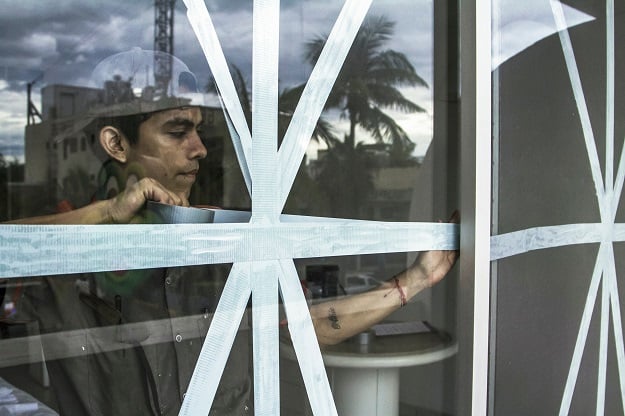 Workers use tape to protect windows from Hurricane Willa, before its arrival in Mazatlan, Sinaloa state, Mexico on October 23, 2018. - Mexico braced Tuesday for the impact of Hurricane Willa as the Category 3 storm barreled toward its Pacific Coast with what forecasters warned would be potentially deadly force. PHOTO: AFP