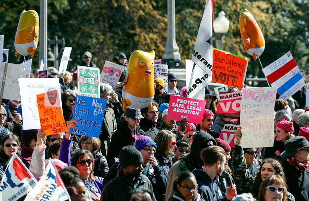 People hold signs during a rally and march at Grant Park, Chicago. PHOTO: AFP