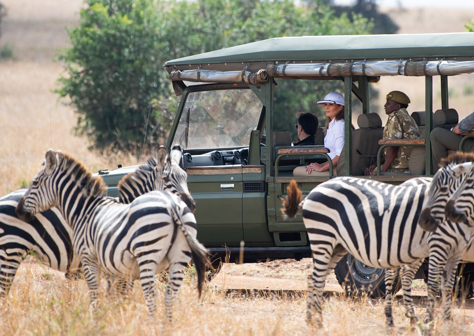 US First Lady Melania Trump looks at zebras as she travels in a vehicle while on a safari at The Nairobi National Park AFP