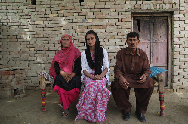 Nawaz sits with her parents at their home. PHOTO: AFP.