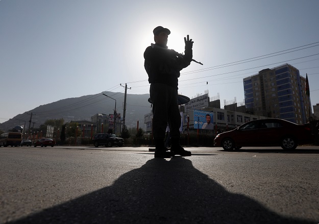 An Afghan policeman stands guard at a checkpoint a day before parliamentary elections in Kabul, Afghanistan October 19, 2018. 