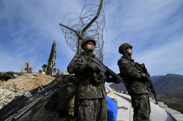 south korean soldiers stand guard as construction equipment destroy a guard post in the demilitarized zone dividing the two koreas in cheorwon on november 15 2018 photo reuters