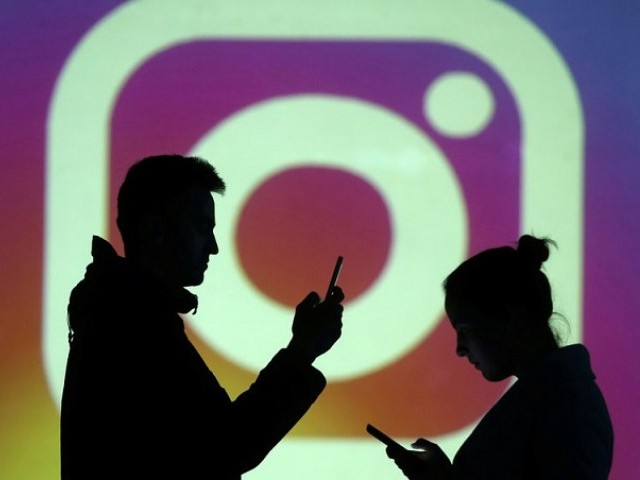 Silhouettes of mobile users are seen next to a screenshot of the Instagram logo in this illustration taken on March 28, 2018.
PHOTO: REUTERS