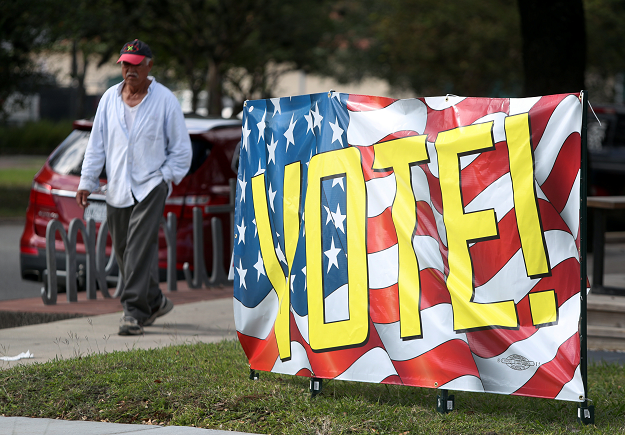  A man walks near a banner urging people to vote in the midterm elections in Houston. PHOTO: REUTERS