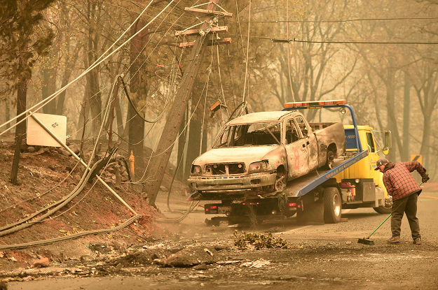 Crews begin removing abandoned vehicles from the streets after the Camp fire. PHOTO: AFP