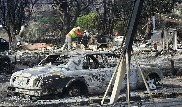 Workers check for gas lines amid the damaged homes from the Woolsey Fire on Filaree Heights Road. PHOTO: AFP