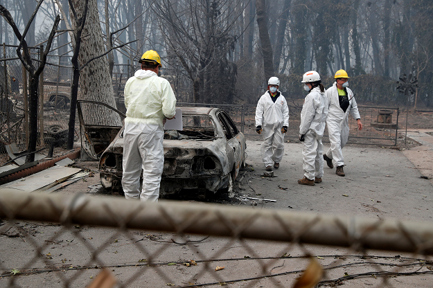  Members of a volunteer search and rescue team from Marin County search for human remains in a car destroyed by the Camp Fire. PHOTO: REUTERS